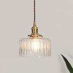 Round glass pendant light with textured shade and brass fitting