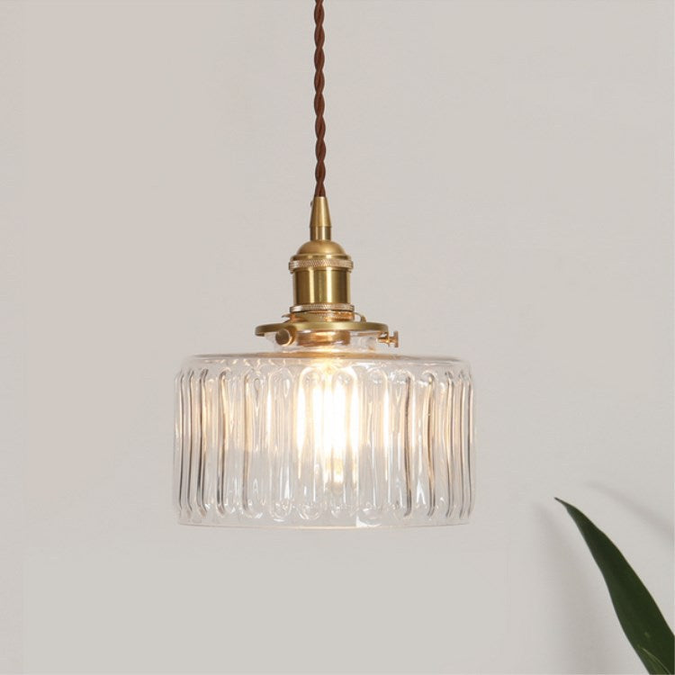 Round glass pendant light with textured shade and brass fitting