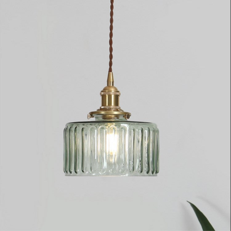 Round glass pendant light with textured shade and brass fitting
