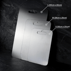 Three grey metal cutting boards with rounded corners and hanging handles