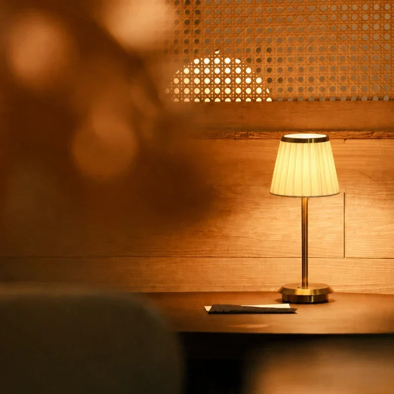 Table lamp with pleated shade, slim stem and round base
