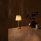 Table lamp with pleated shade, slim stem and round base