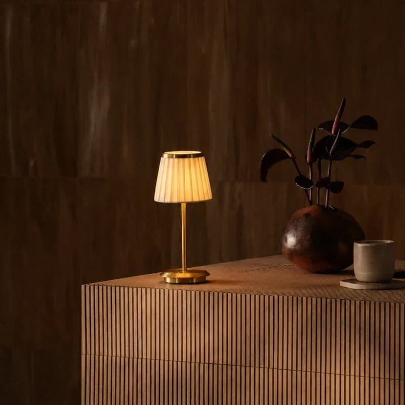 Table lamp with pleated shade, slim stem and round base