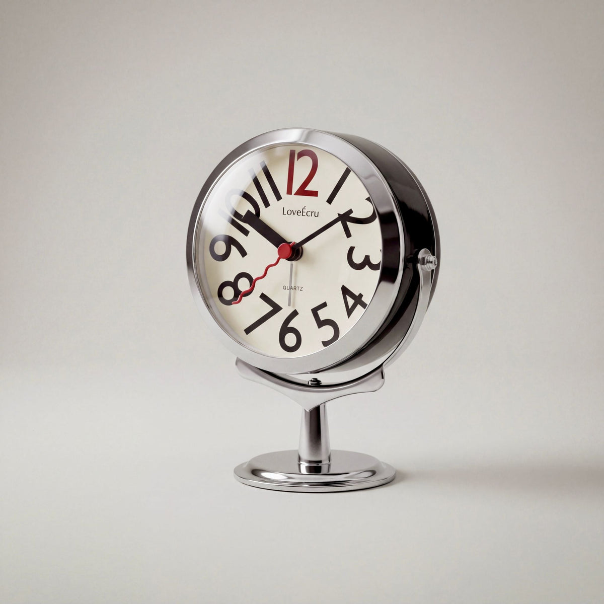Round analogue alarm clock with bold numerals and raised metallic-effect stand