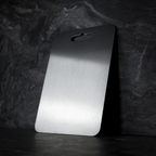 Three grey metal cutting boards with rounded corners and hanging handles