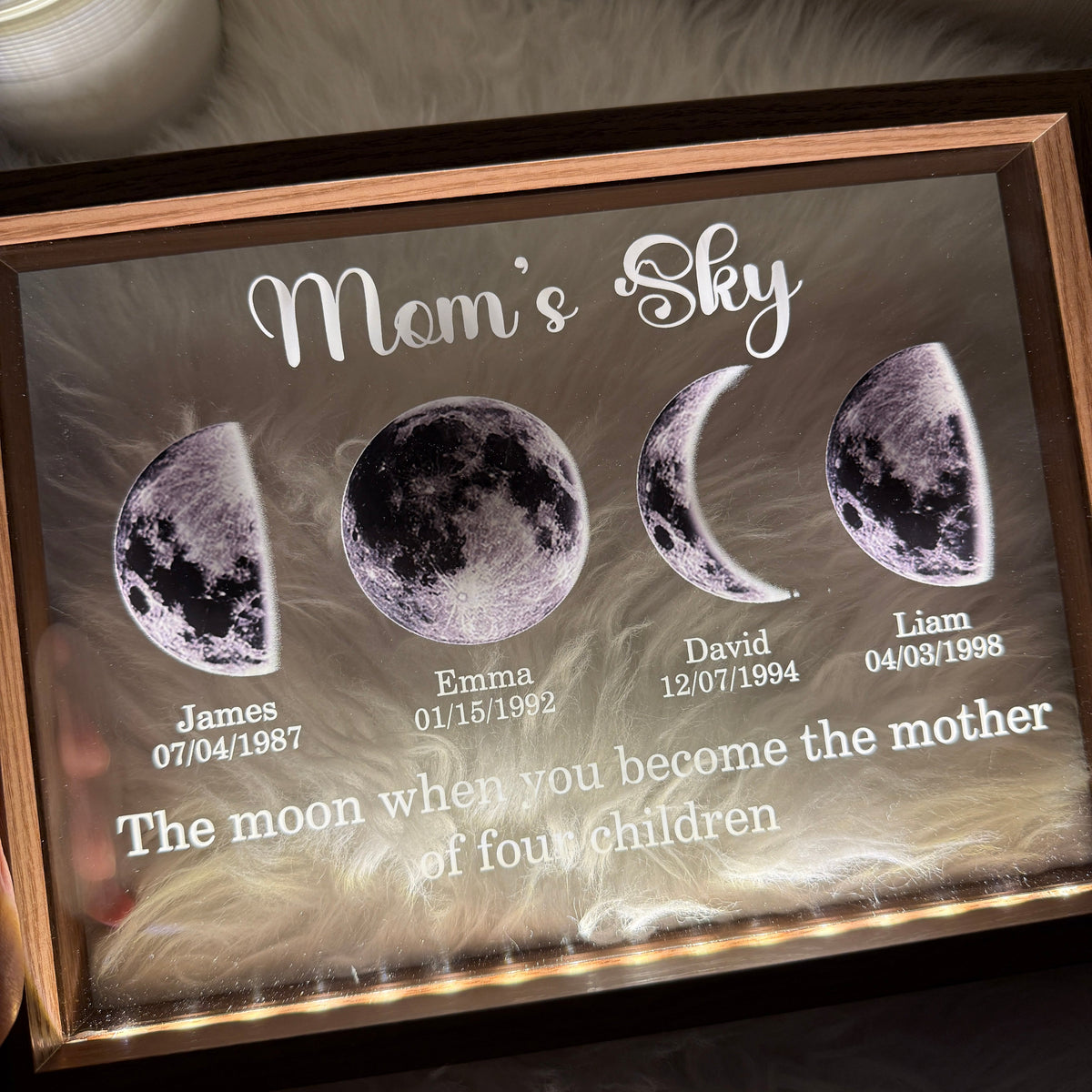 Illuminated black framed moon phase family display with names and dates
