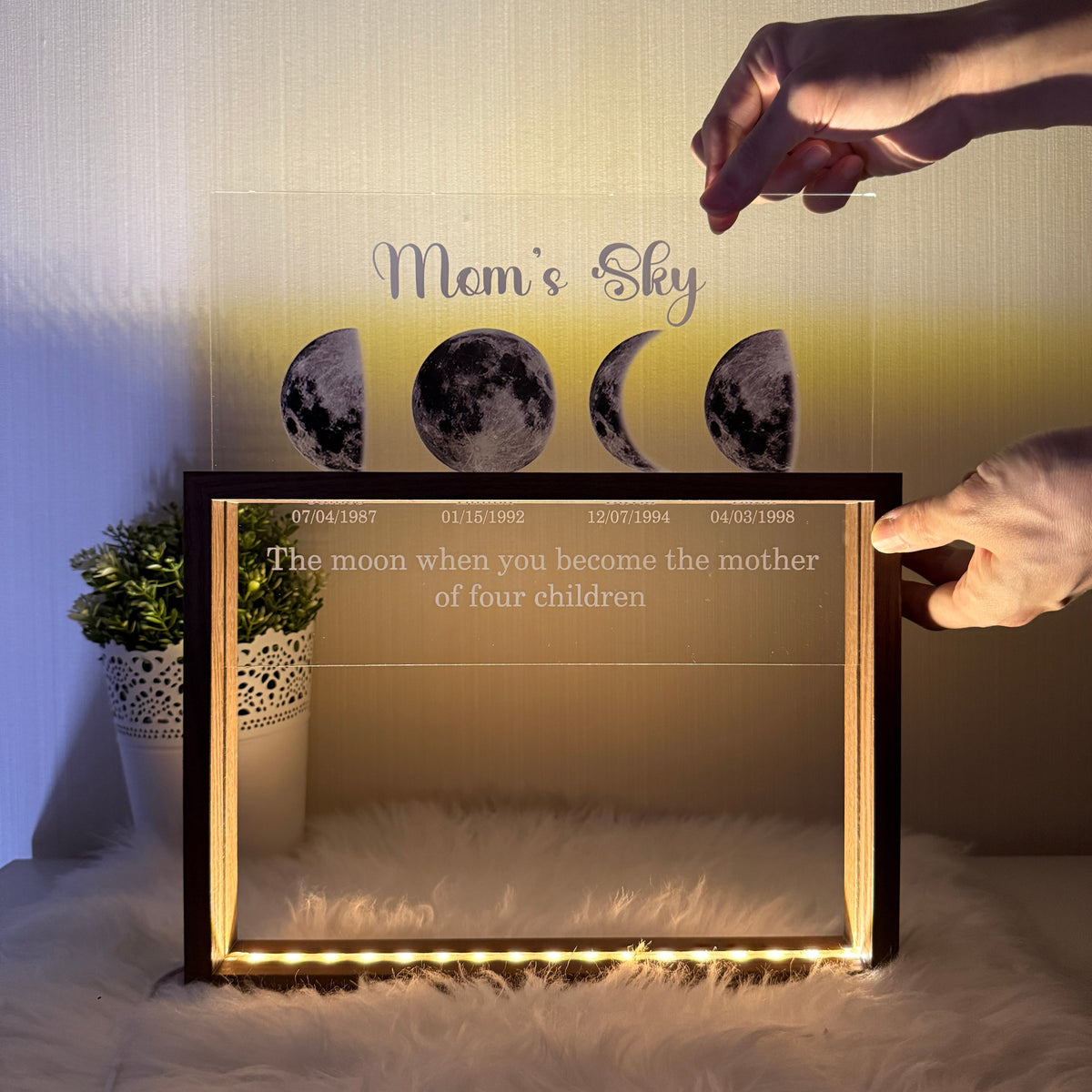 Illuminated black framed moon phase family display with names and dates