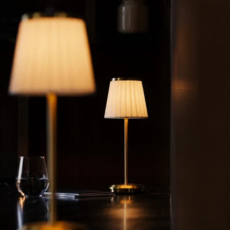 Table lamp with pleated shade, slim stem and round base