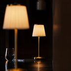 Table lamp with pleated shade, slim stem and round base
