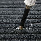 Rectangular ribbed striped doormat with dark edging by an entrance