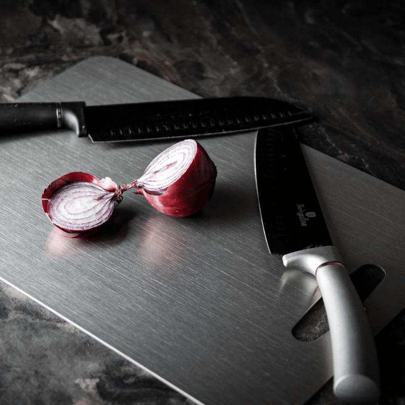 Three grey metal cutting boards with rounded corners and hanging handles