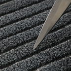 Rectangular ribbed striped doormat with dark edging by an entrance