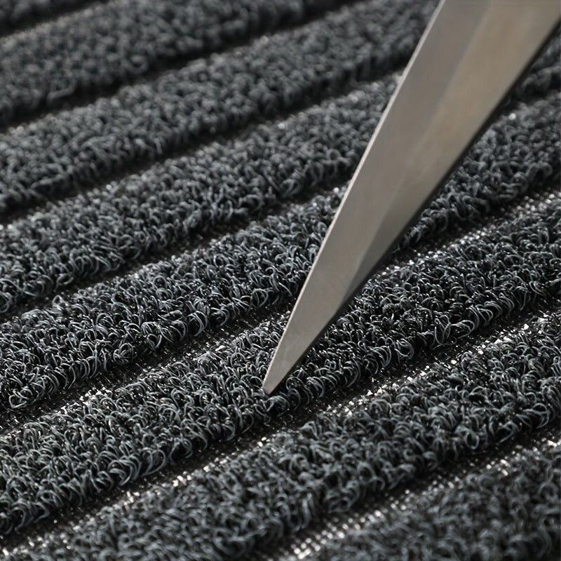 Rectangular ribbed striped doormat with dark edging by an entrance