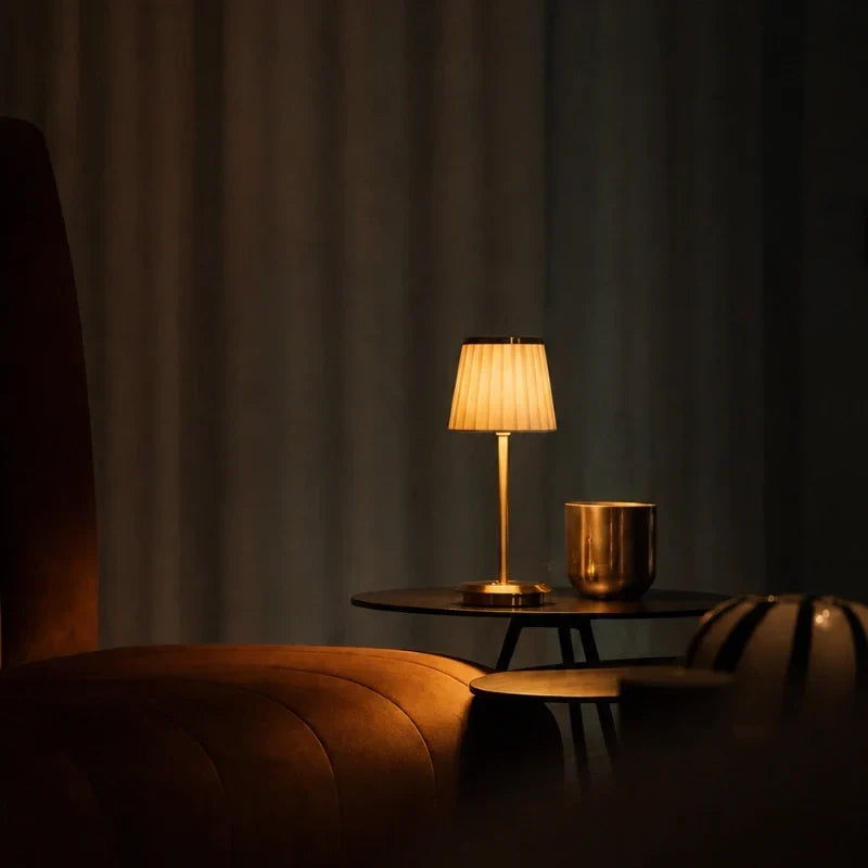 Table lamp with pleated shade, slim stem and round base