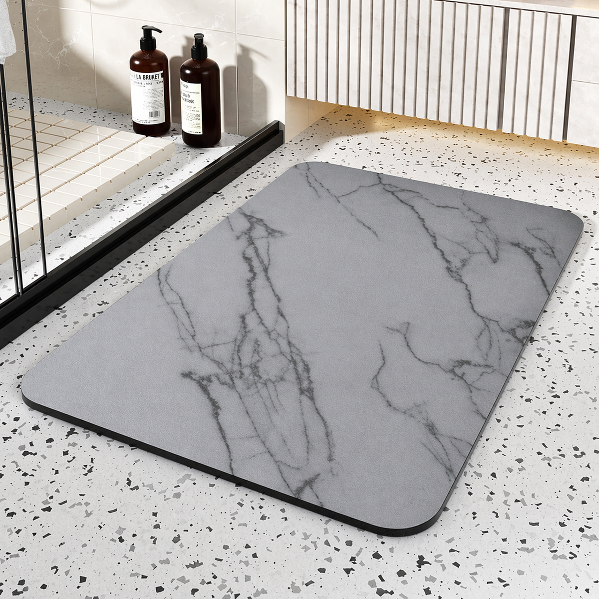 Black rectangular bathroom mat with white marble-effect veining and rounded corners