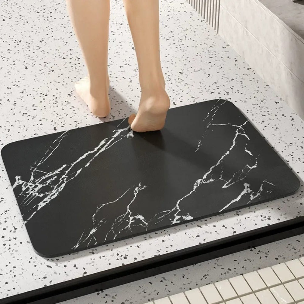 Black rectangular bathroom mat with white marble-effect veining and rounded corners