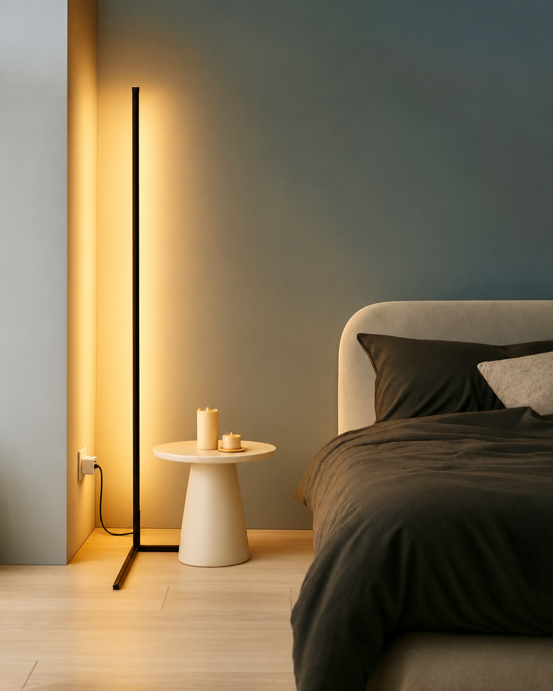 Slim black floor lamp casting a warm glow beside a bed