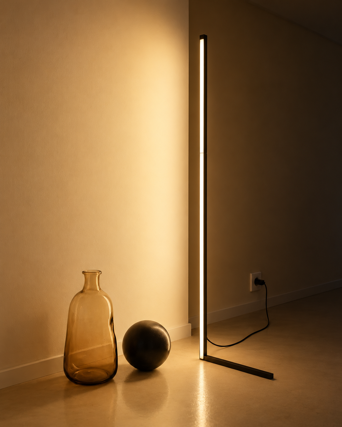 Slim black floor lamp casting a warm glow beside a bed