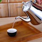 Lidded induction stovetop kettle with curved spout and raised handle