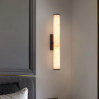 Vertical alabaster column wall sconce emitting warm light