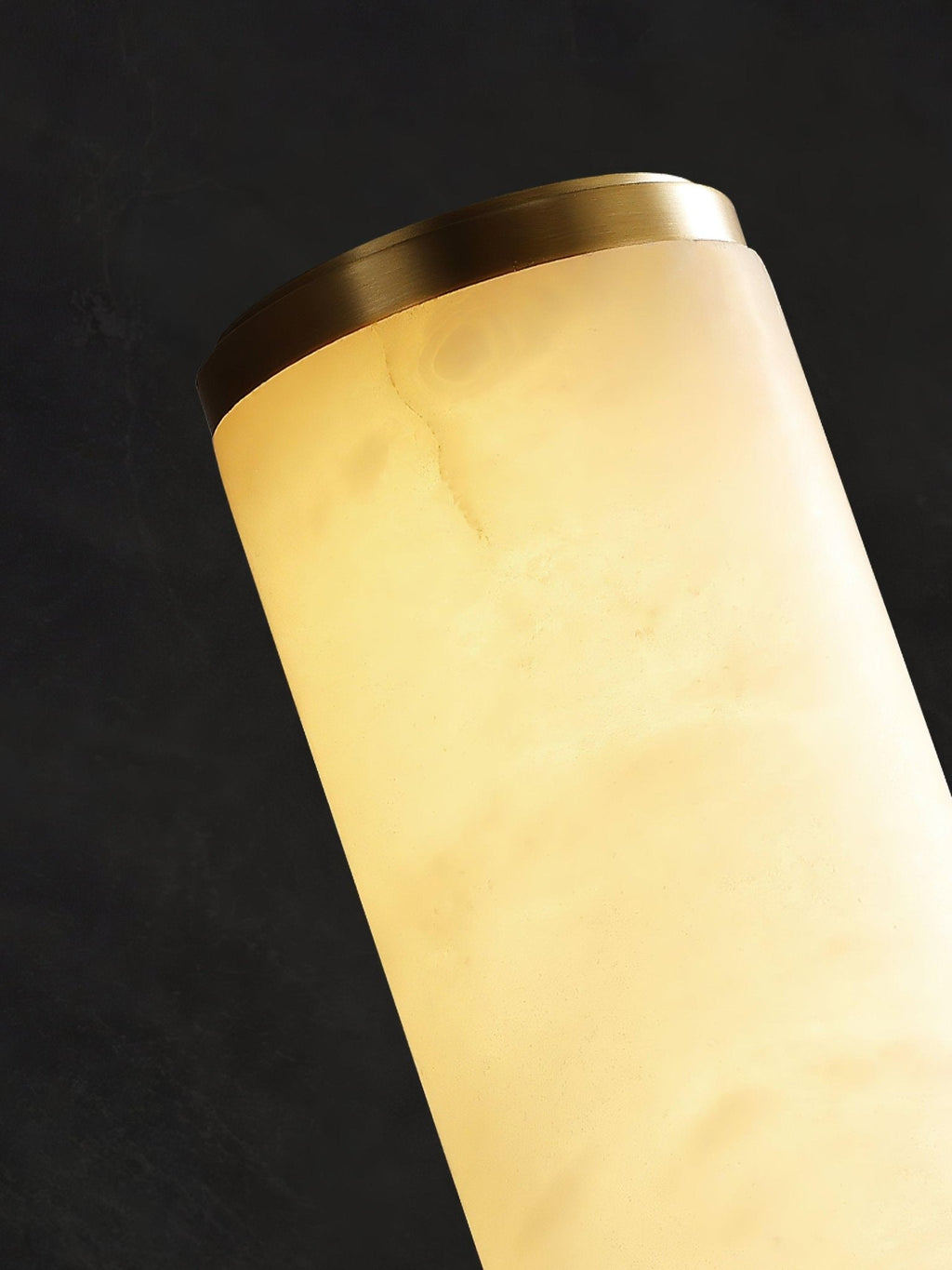 Vertical alabaster column wall sconce emitting warm light