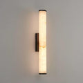Vertical alabaster column wall sconce emitting warm light