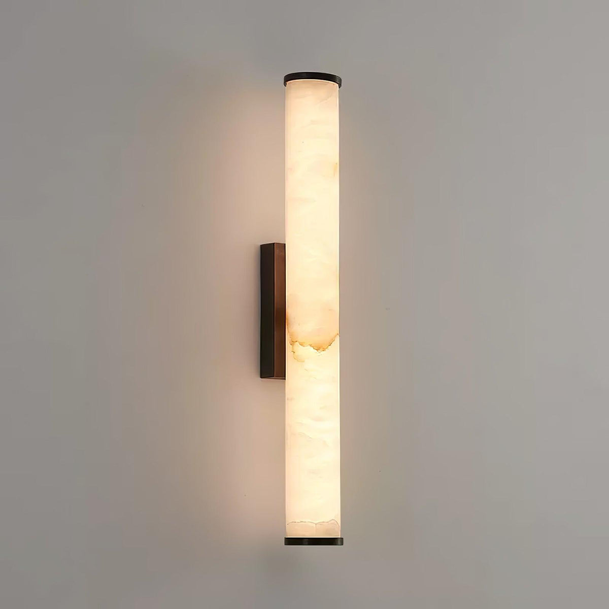 Vertical alabaster column wall sconce emitting warm light