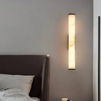 Vertical alabaster column wall sconce emitting warm light