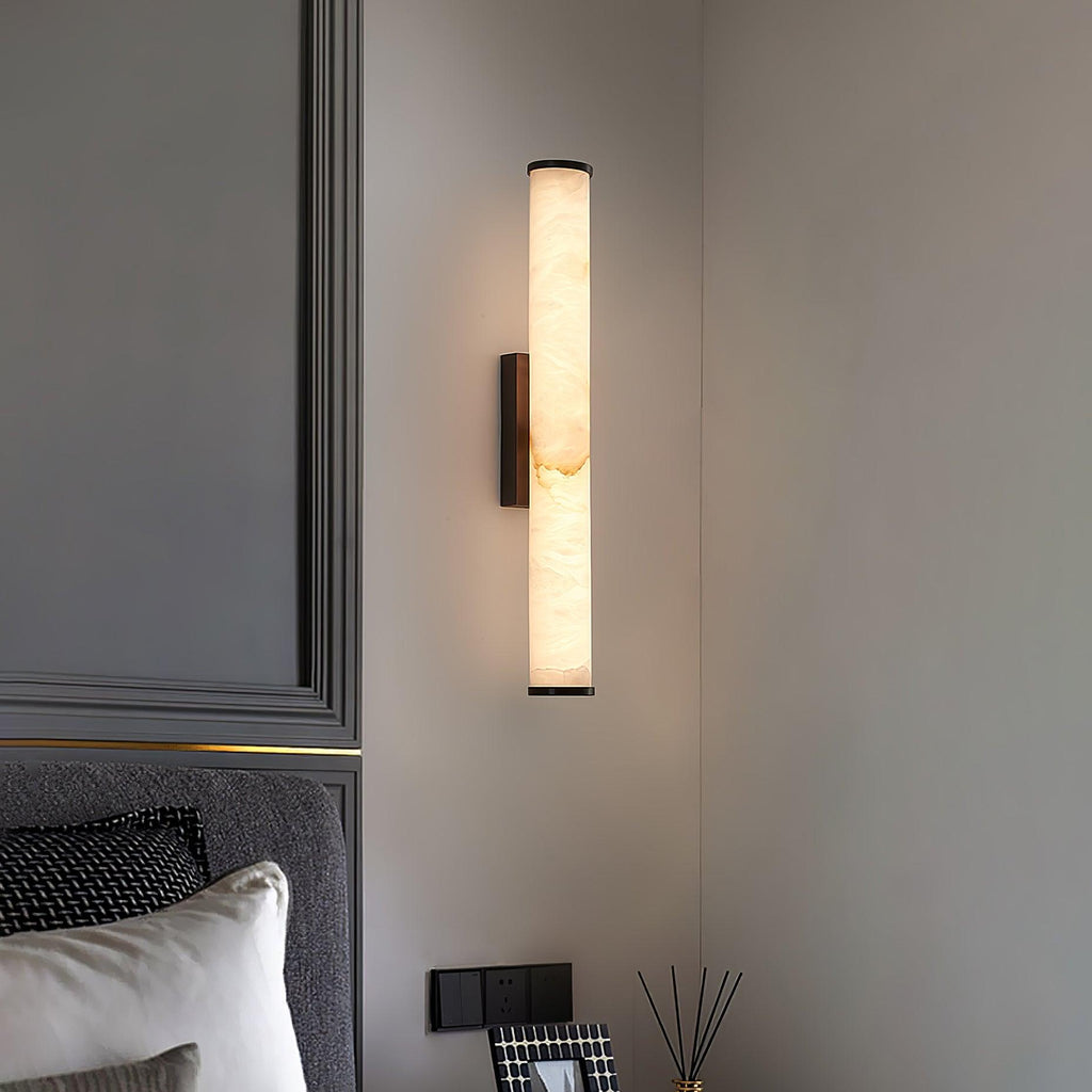 Vertical alabaster column wall sconce emitting warm light