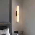 Vertical alabaster column wall sconce emitting warm light
