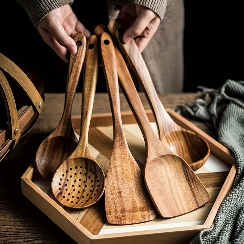 Five-piece brown wooden kitchen utensil set with spoons, slotted spoon and spatula