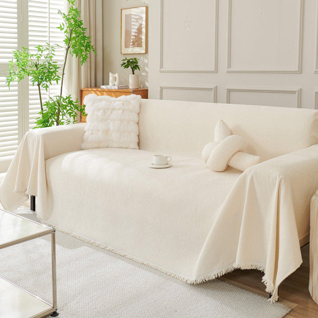 Draped sofa cover with fringed edges in a living room