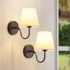 Wall lamp with tapered fabric shade and curved arm