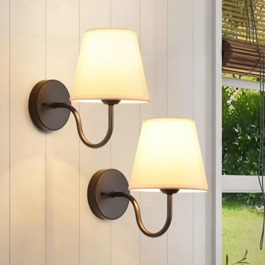 Wall lamp with tapered fabric shade and curved arm