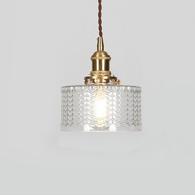 Round glass pendant light with textured shade and brass fitting