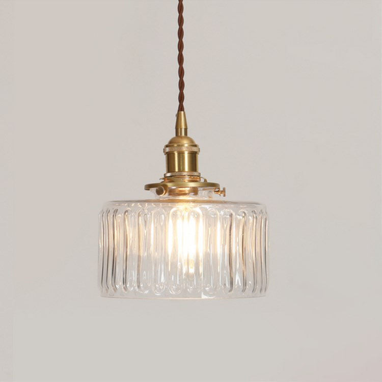 Round glass pendant light with textured shade and brass fitting