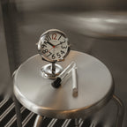 Round analogue alarm clock with bold numerals and raised metallic-effect stand