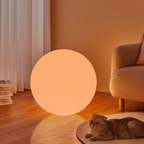Spherical cordless LED table lamp glowing with coloured light