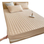 Quilted mattress protector with a padded square design on a bed