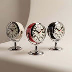 Round analogue alarm clock with bold numerals and raised metallic-effect stand
