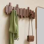 Wall-mounted coat rack with slatted panel and fold-down hooks