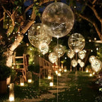 Clear LED balloons with warm white string lights along a garden path