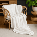 Textured blanket throw with a wavy woven surface draped over a chair