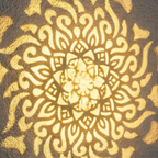 Black cylindrical solar mandala projector light casting a patterned glow outdoors