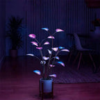 App-controlled LED plant light with glowing leaves in a white pot