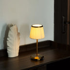 Table lamp with pleated shade, slim stem and round base