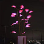 App-controlled LED plant light with glowing leaves in a white pot