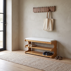 Brown bamboo shoe bench with white padded seat and two open storage shelves