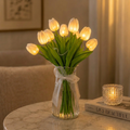 Illuminated tulip flower bouquet with green leaves in a clear vase